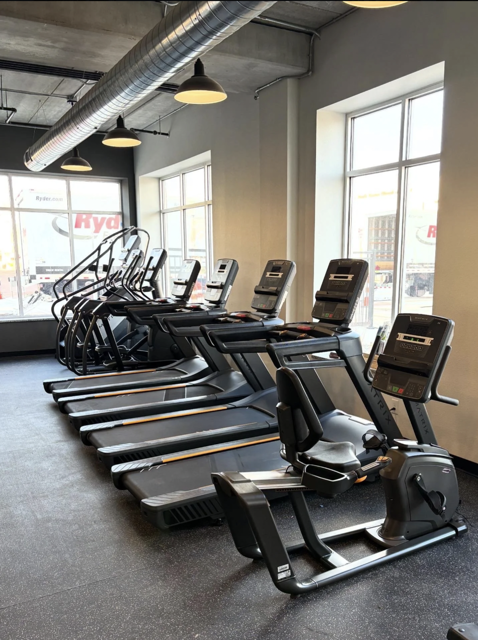 Matrix treadmills, ellipticals, and a recumbent bike by the windows at PKFit Wausau