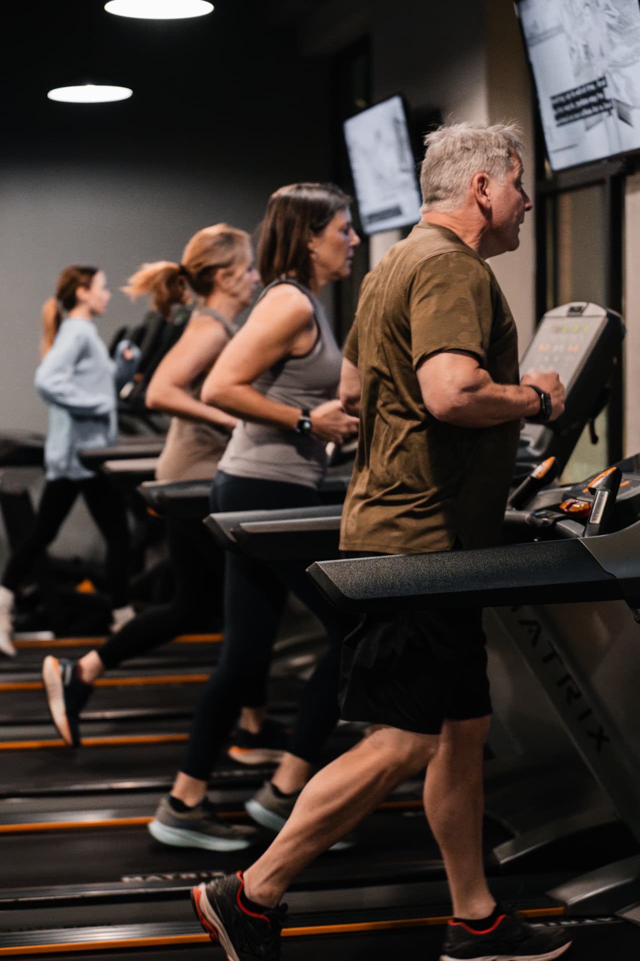 Members running on treadmills during a PKFit cardio session