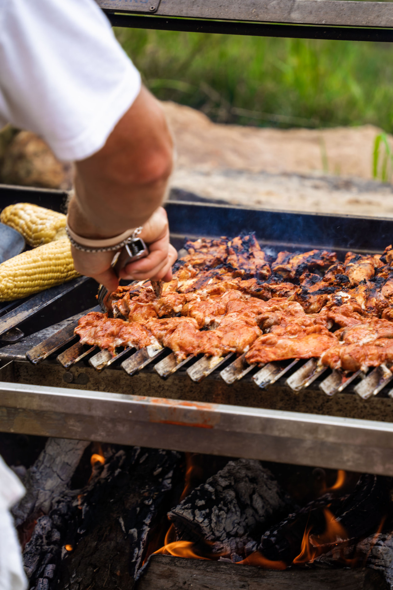 Chicken and corn cooking over an open wood fire at the retreat