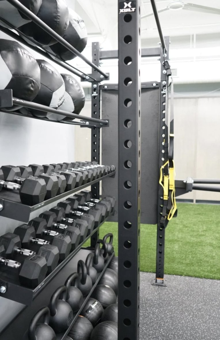 Dumbbells, kettlebells, and wall balls on the University Row turf