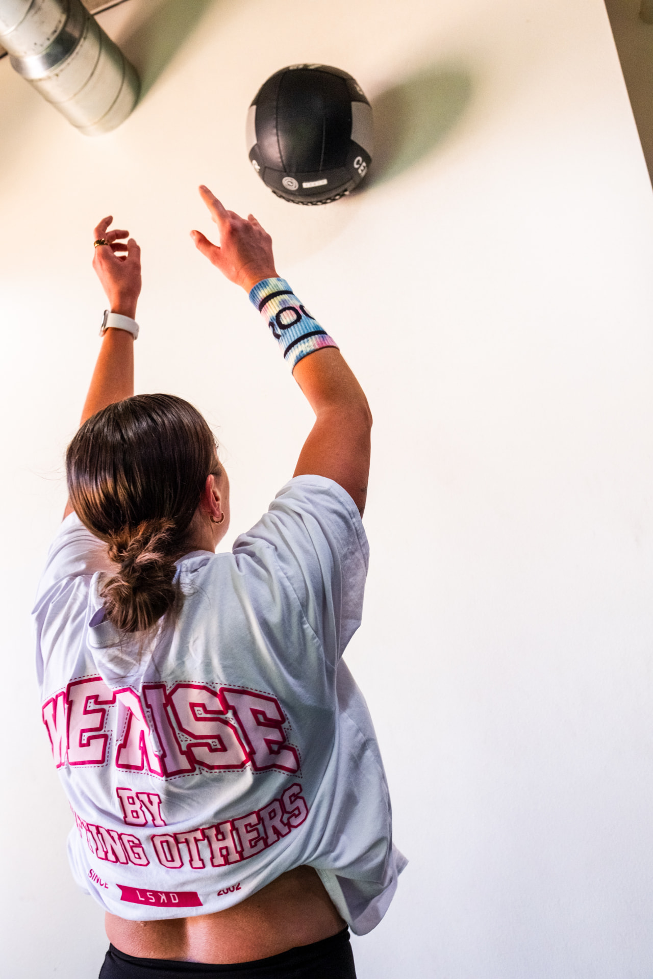 A member releasing a medicine ball toward the wall during a class