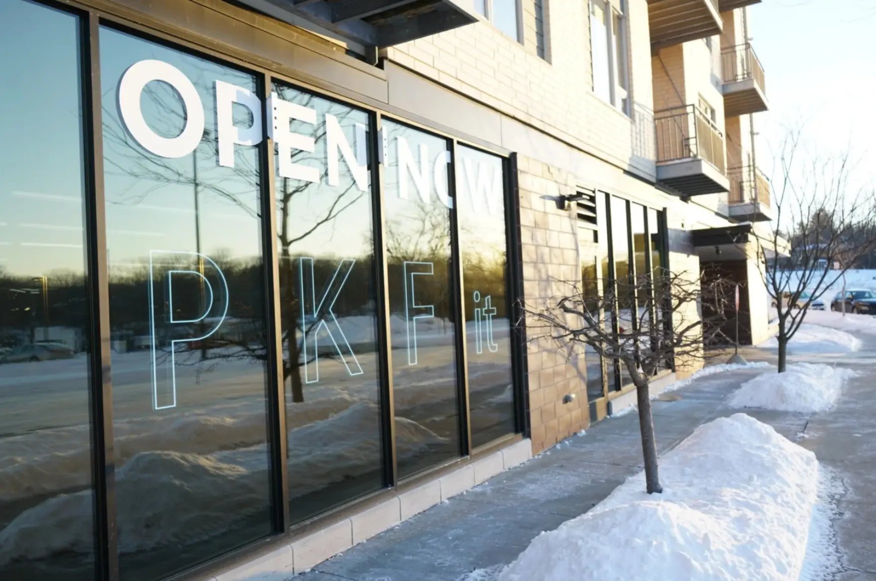 The PKFit University Row storefront with an Open Now sign in the snow