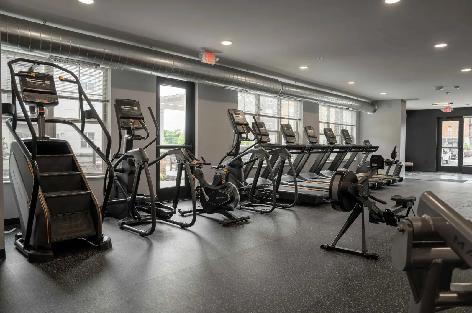 The cardio floor at PKFit Verona with a stair climber, ellipticals, and a rowing machine