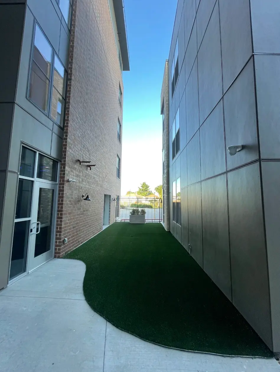 The outdoor turf strip between the buildings at PKFit Park Street