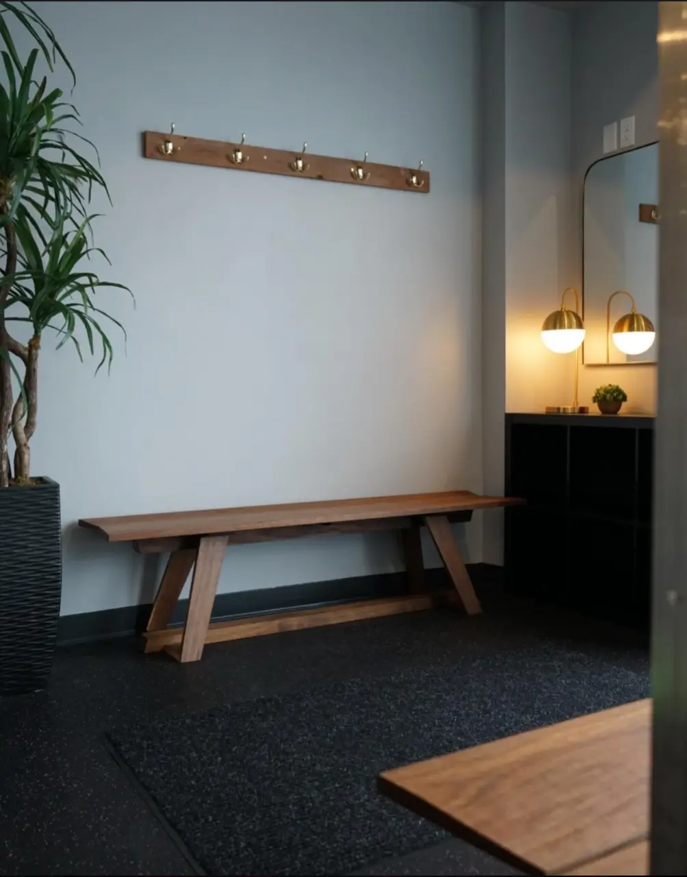 The PKFit Park Street entry with a wooden bench, coat hooks, and warm lighting