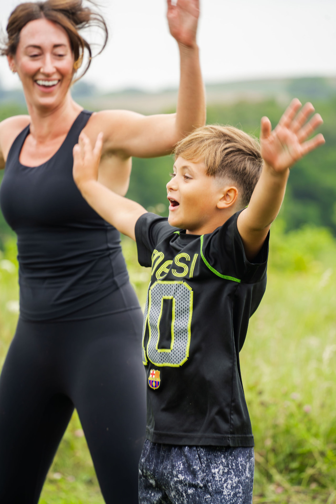 A retreat guest and a young athlete celebrating together in the meadow