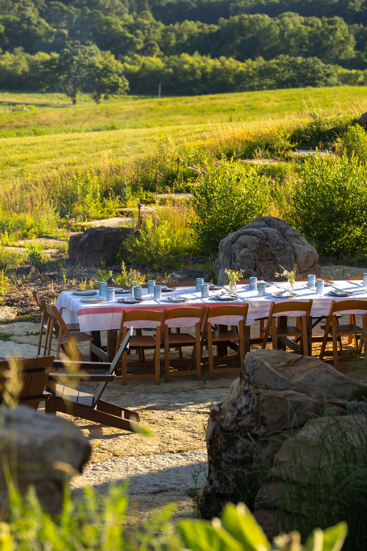 An outdoor table set for a shared meal overlooking the meadows at Flynn Creek Farm