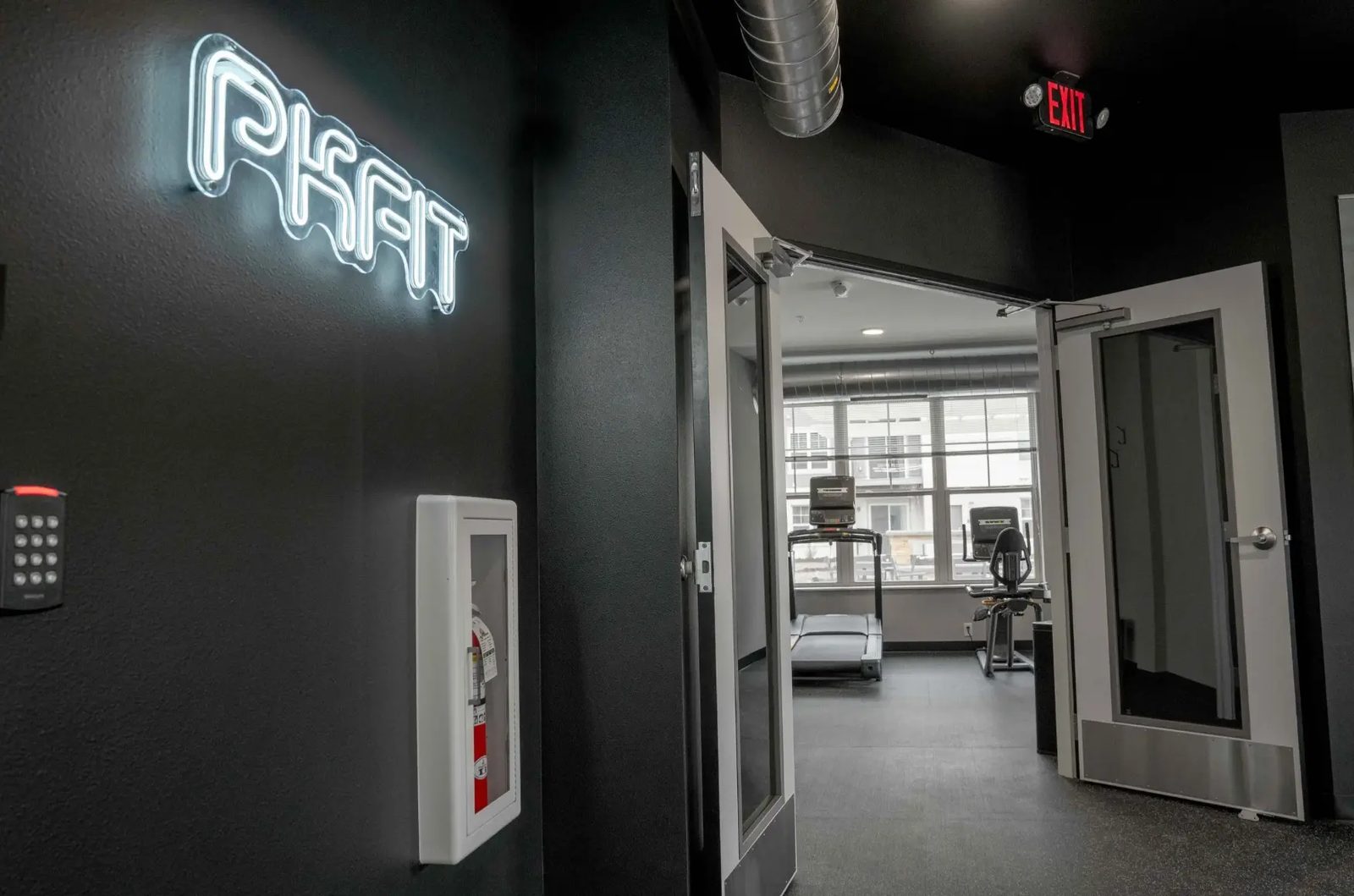 The PKFit neon sign on the black wall at PKFit Verona